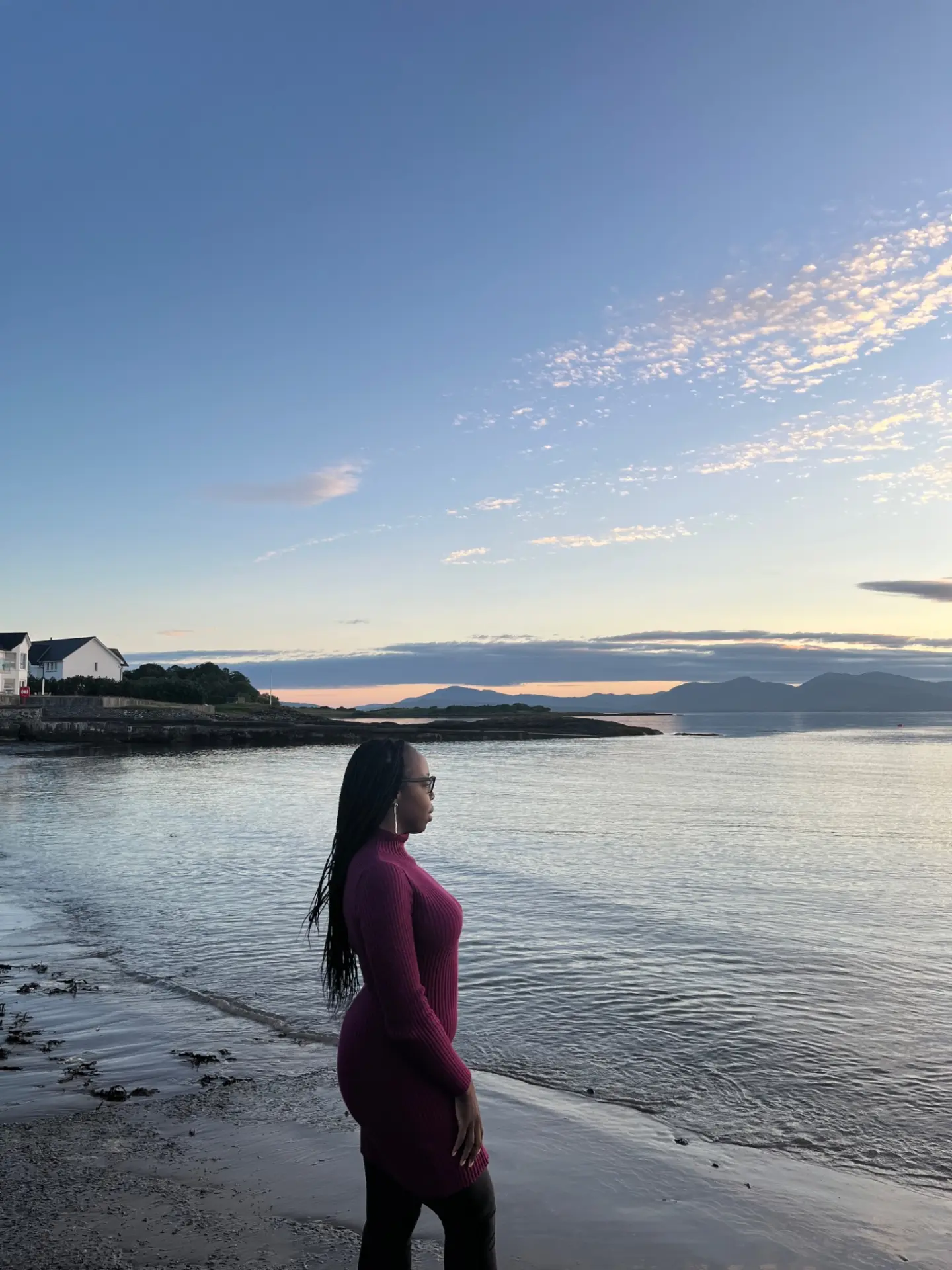 Moi au bord de la mer en Écosse, face aux montagnes au coucher du soleil